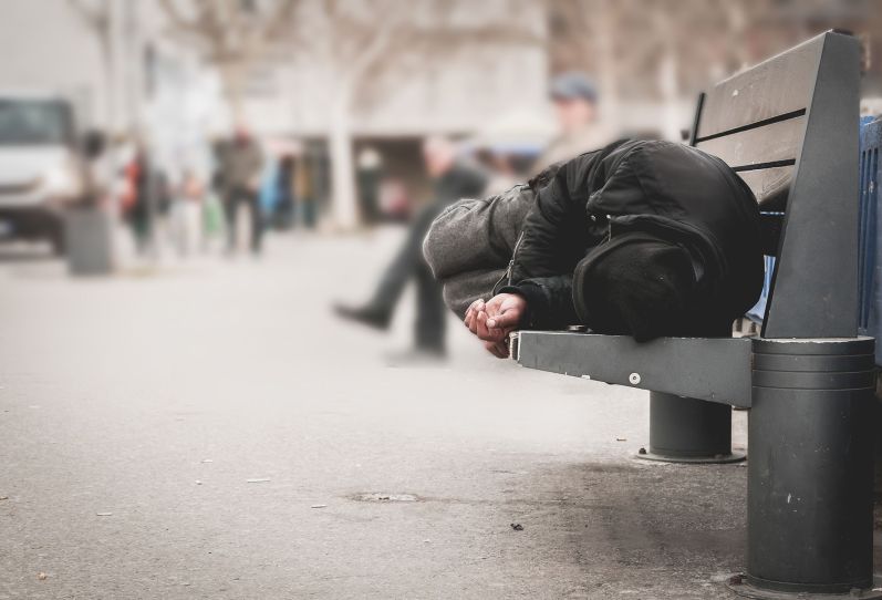 Homeless person sleeping on a bench
