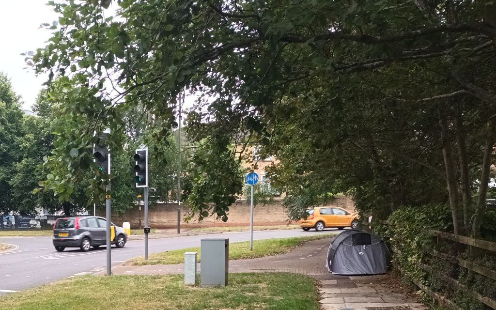 tent pitched at the side of a road